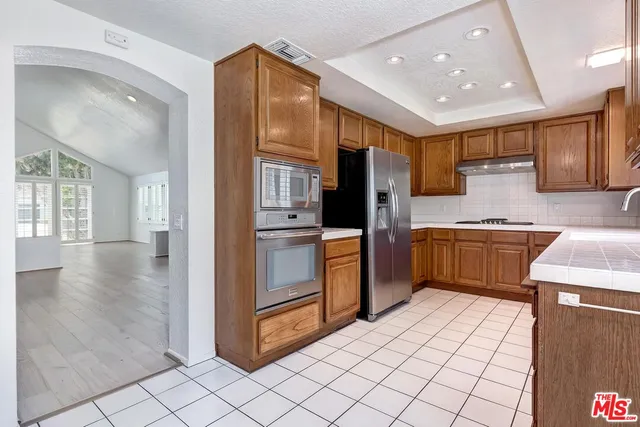 a kitchen with stainless steel appliances a refrigerator and a stove top oven