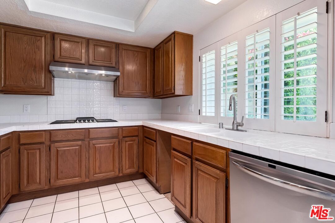 7557 West 82nd Street Playa del Rey, CA 90293 - Photo 17 of 35 a kitchen with stainless steel appliances granite countertop a sink stove and cabinets