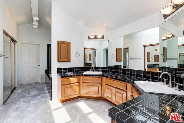 a large kitchen with granite countertop a sink and a counter top space