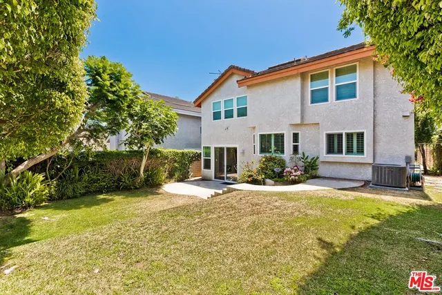 a view of a house with a yard and lawn chairs with a fire pit