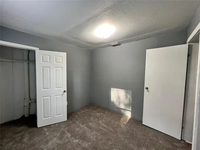 an empty room with closet and mirror