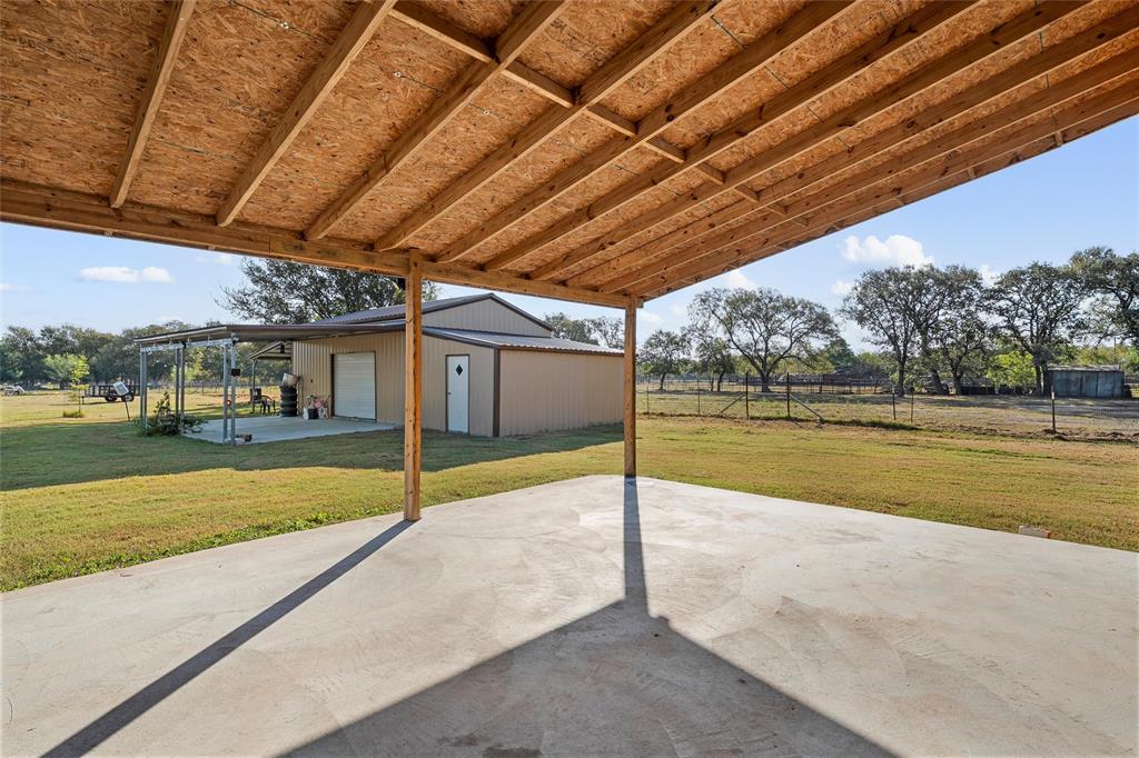1605 Cloverleaf Road Bellmead, TX 76705 - Photo 7 of 29 a view of a patio with a table and chairs under an umbrella