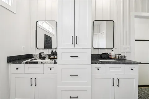 a bathroom with cabinets sink and a mirror