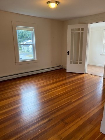 45 Webster Street, Unit 2 Woburn, MA 01801 - Photo 6 of 10 a view of an empty room with wooden floor and a window