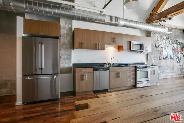 a kitchen with granite countertop stainless steel appliances and wooden floor