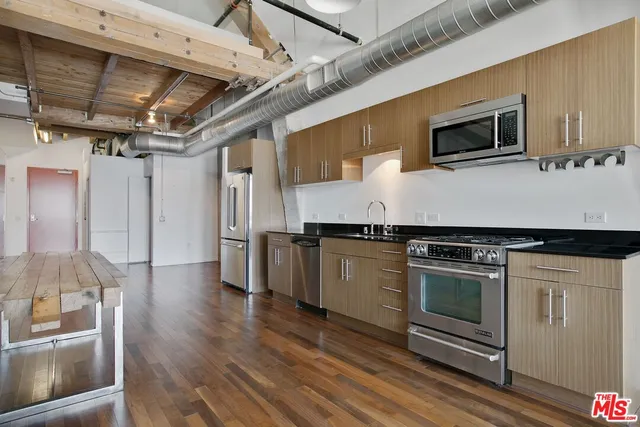 a kitchen with stainless steel appliances granite countertop a stove and a microwave