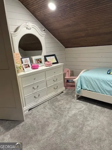 a bedroom with a bed and a flat tv screen on dresser