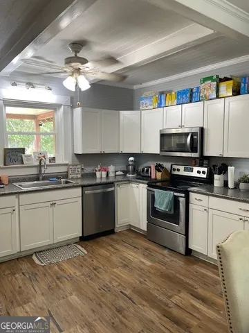 a kitchen with granite countertop stainless steel appliances a sink and cabinets