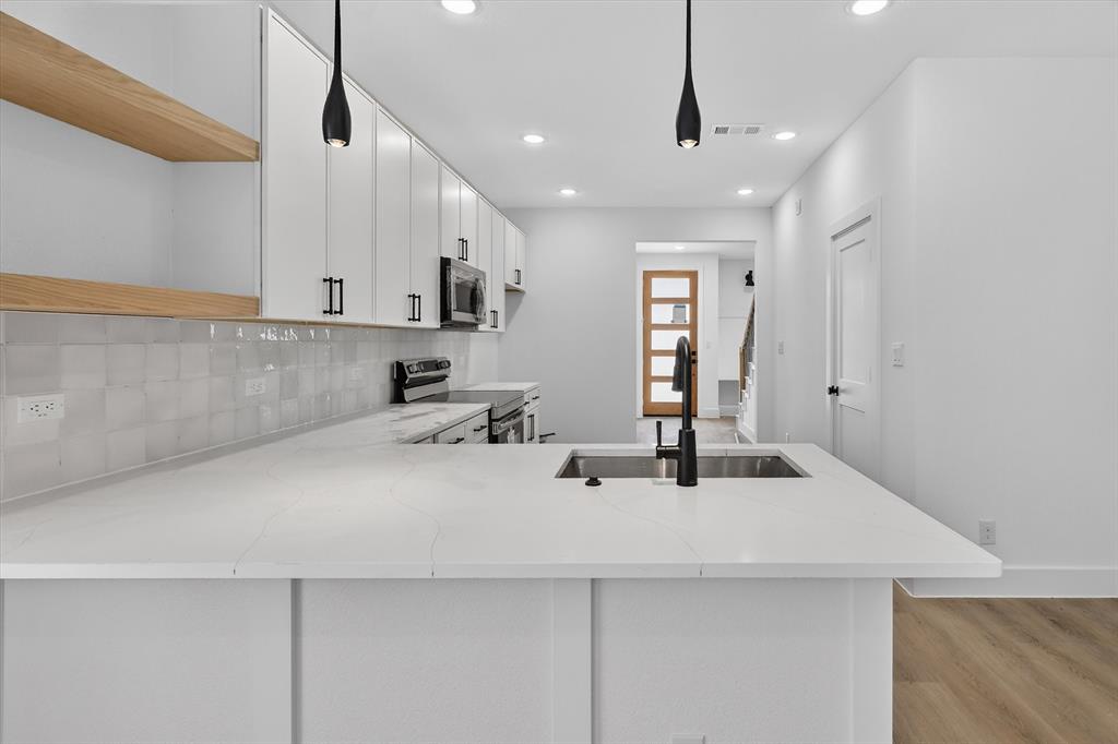 2835 Macon Street Dallas, TX 75215 - Photo 5 of 14 a kitchen with stainless steel appliances a sink a center island and cabinets