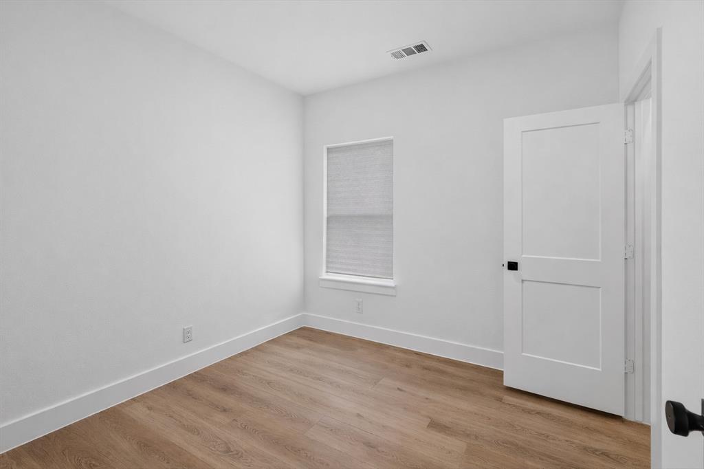 2835 Macon Street Dallas, TX 75215 - Photo 10 of 14 a view of an empty room with wooden floor and a window