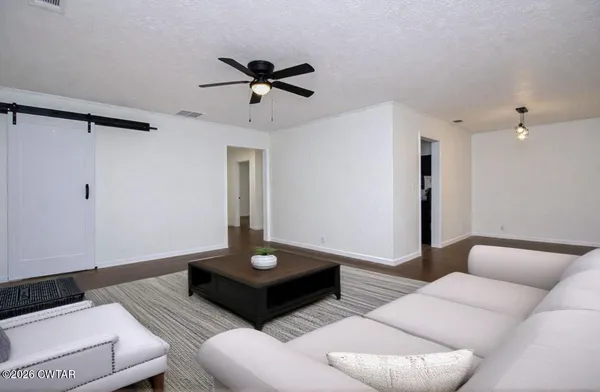 a living room with furniture and a wooden floor