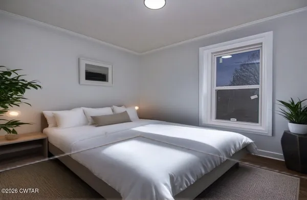 a bedroom with bed and a potted plant