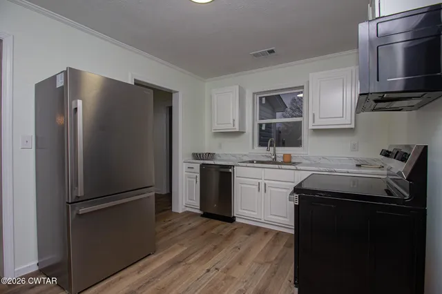 a kitchen with a refrigerator sink and microwave