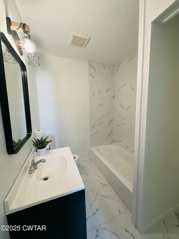 a bathroom with a sink a mirror and a bathtub