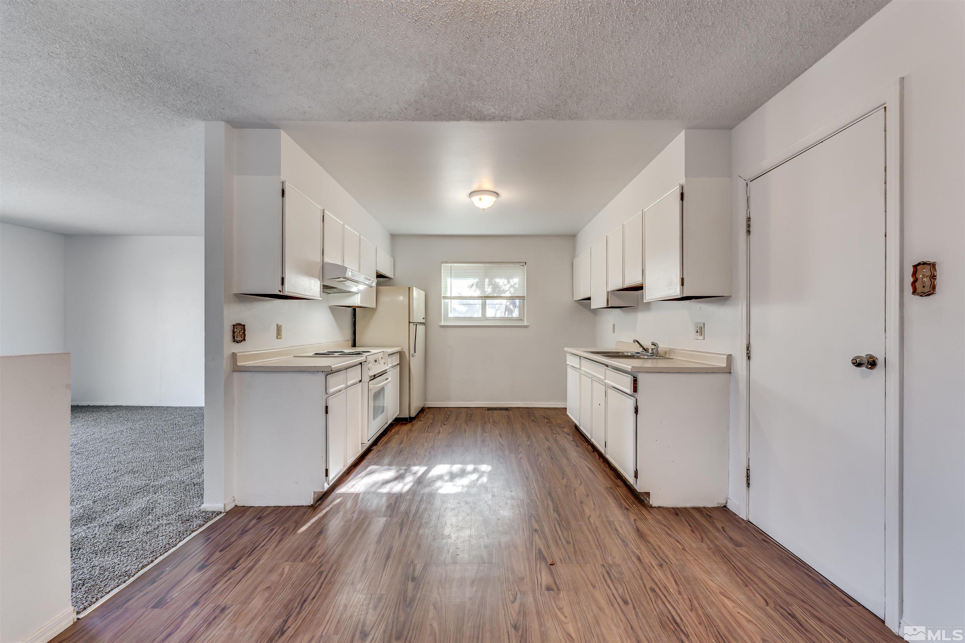 658 Beldon Way Reno, NV 89503 - Photo 7 of 21 a kitchen with white cabinets and white appliances