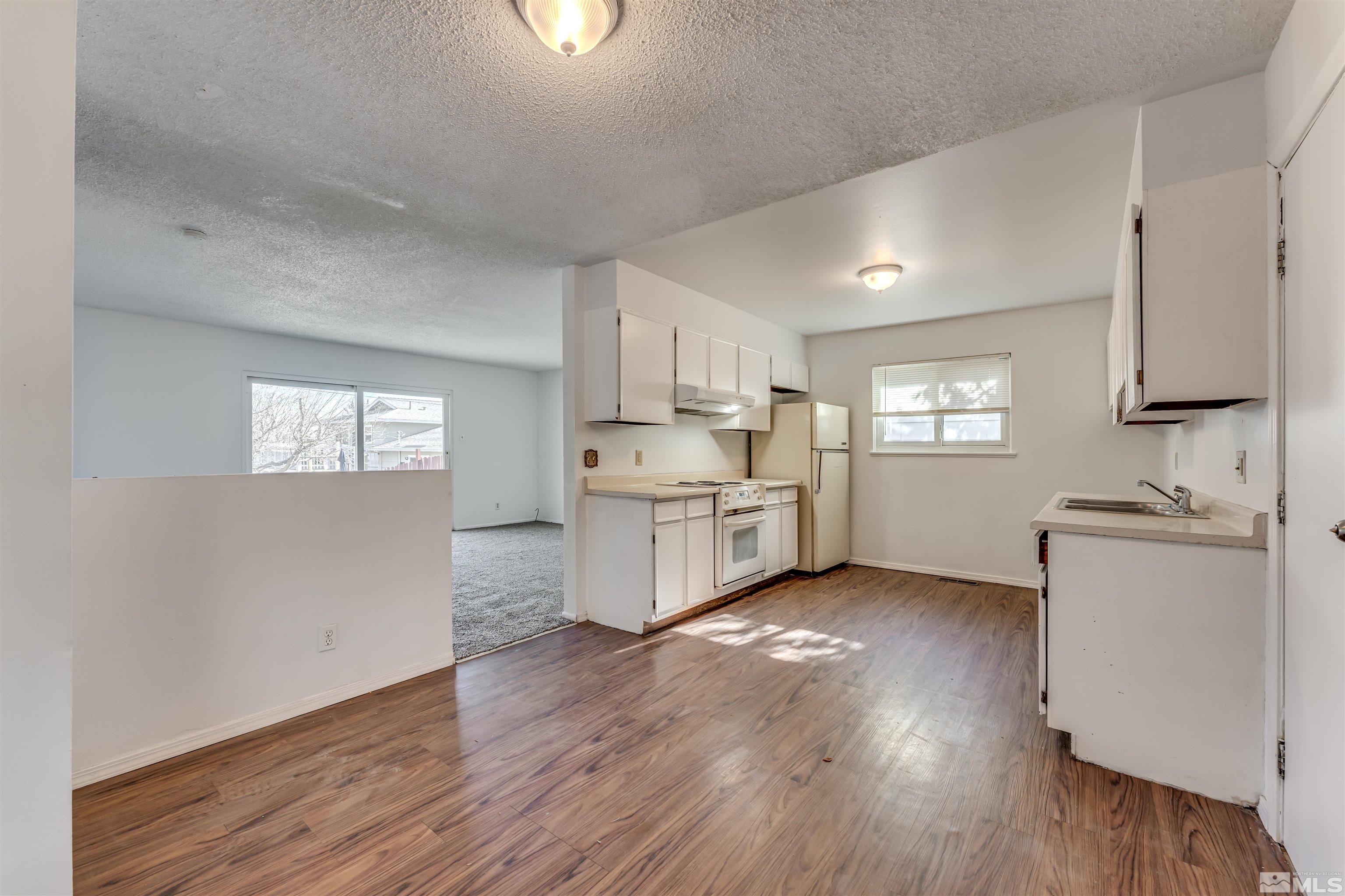 658 Beldon Way Reno, NV 89503 - Photo 8 of 21 a kitchen with stainless steel appliances granite countertop a sink cabinets and wooden floor