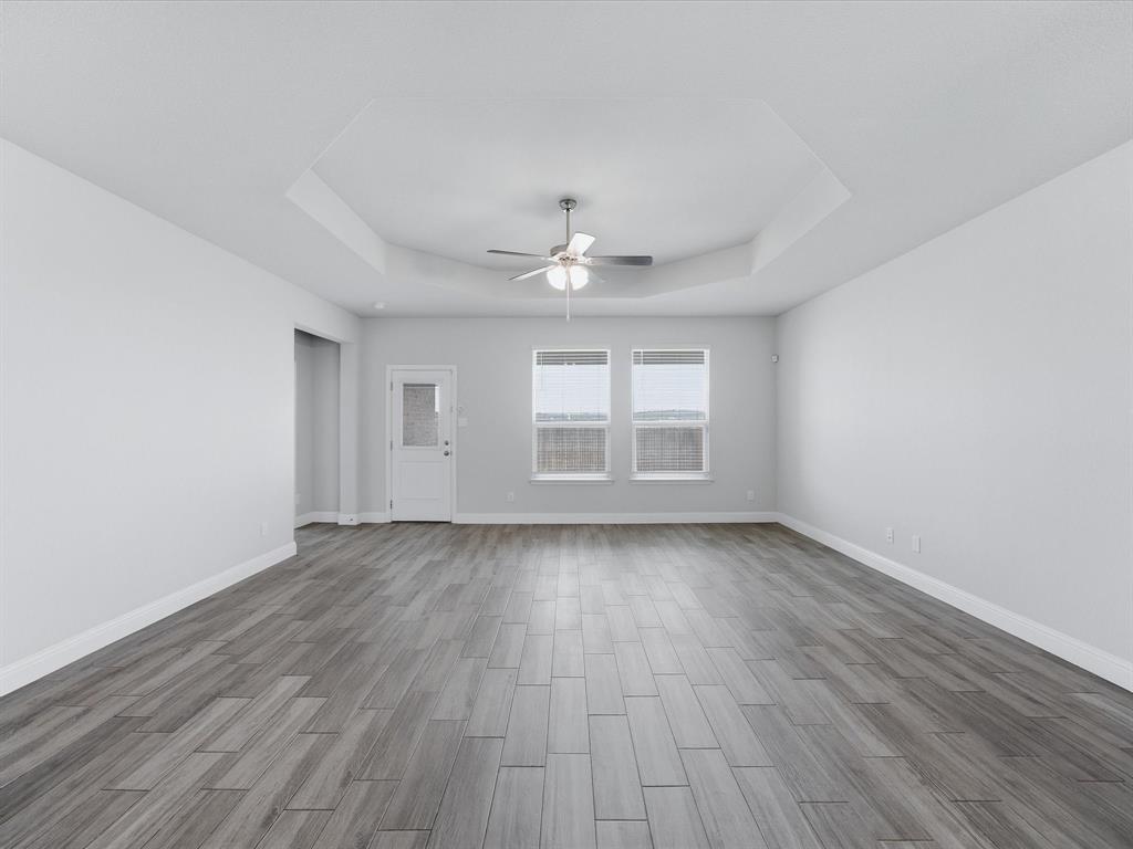 1121 Knightsbridge Road Argyle, TX 76226 - Photo 19 of 39 Spacious interior featuring wood-finish flooring, a tray ceiling with a fan light fixture, and multiple windows