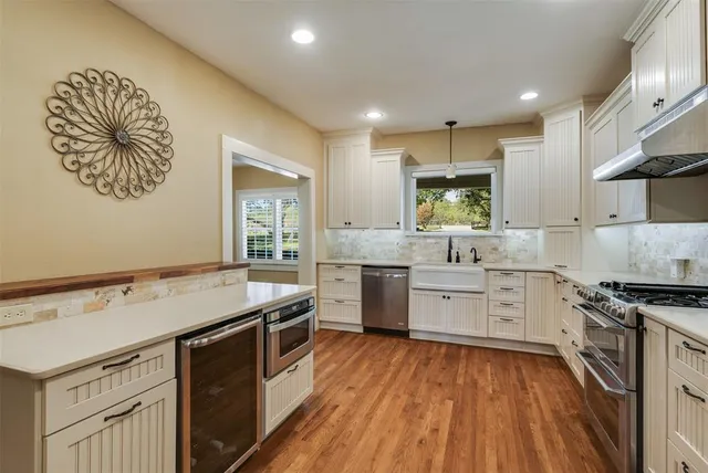 a view of a livingroom with wooden floor and a workspace
