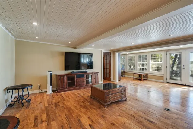 a living room with furniture a wooden floor and next to a window