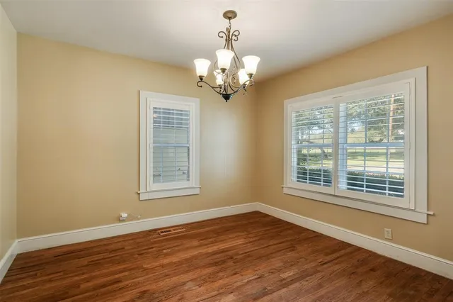 a view of a large room with wooden floor and windows