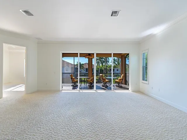 an empty room with furniture and large windows