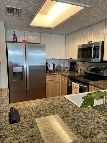 a view of an empty room with wooden floor fireplace and a window