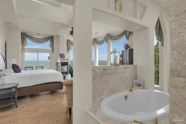 a living room with stainless steel appliances furniture a rug and a kitchen view