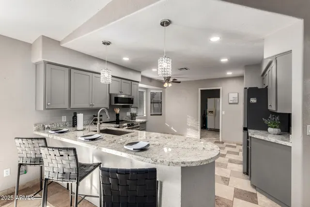 a kitchen with stainless steel appliances kitchen island granite countertop a sink and cabinets