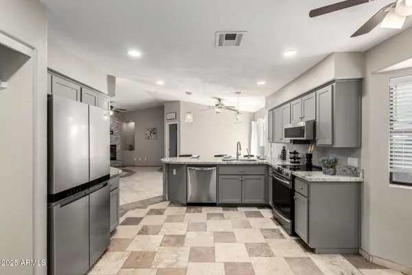 a kitchen with stainless steel appliances granite countertop a sink stove and refrigerator
