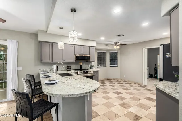 a kitchen with kitchen island a sink dining table and chairs