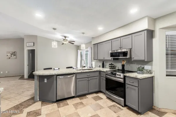 a kitchen with stainless steel appliances granite countertop a sink a stove top oven a counter space and cabinets