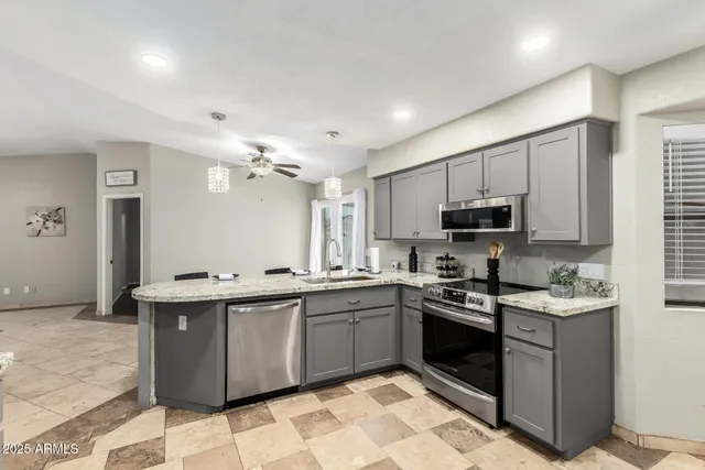 a kitchen with stainless steel appliances granite countertop a sink a stove top oven a counter space and cabinets