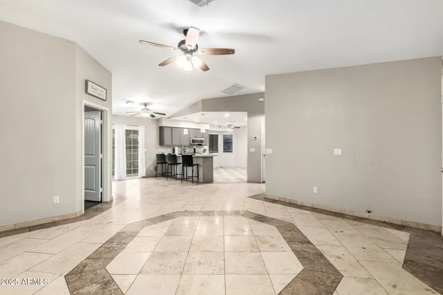 a view of a livingroom with a dinning area hardwood floor and a ceiling fan