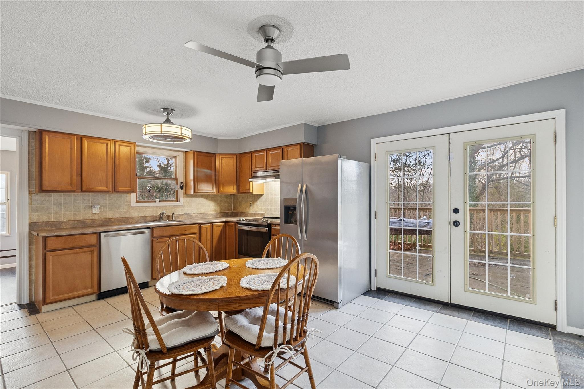 361 Decatur Avenue Shirley, NY 11967 - Photo 26 of 33 Large Kitchen with stainless steel appliances, brown cabinetry, decorative backsplash, French doors,