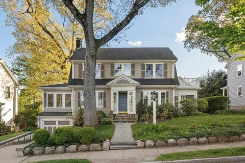 a front view of a house with yard and green space