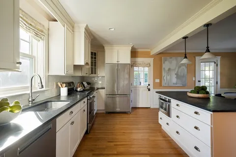 a large kitchen with stainless steel appliances granite countertop a sink stove and refrigerator