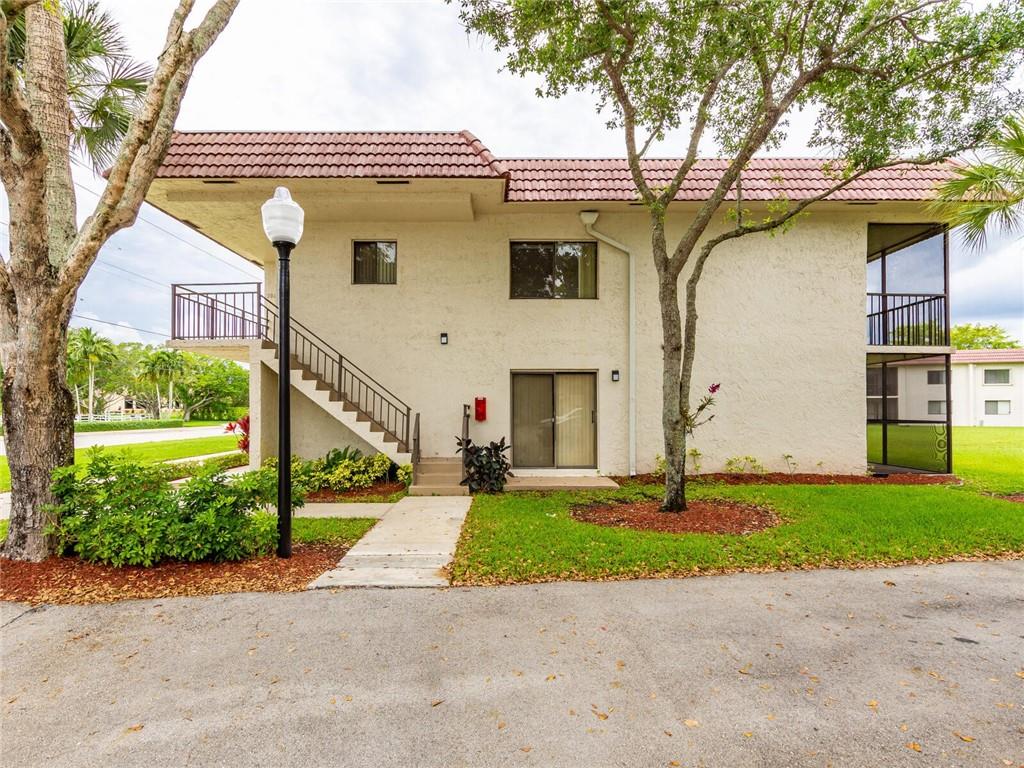 16243 Saddle Club Road, Unit 204 Weston, FL 33326 - Photo 1 of 48 a view of a white house with a yard and a large tree