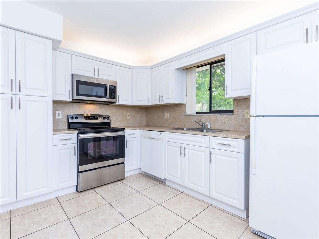 16243 Saddle Club Road, Unit 204 Weston, FL 33326 - Photo 8 of 48 a kitchen with granite countertop white cabinets a sink and a window