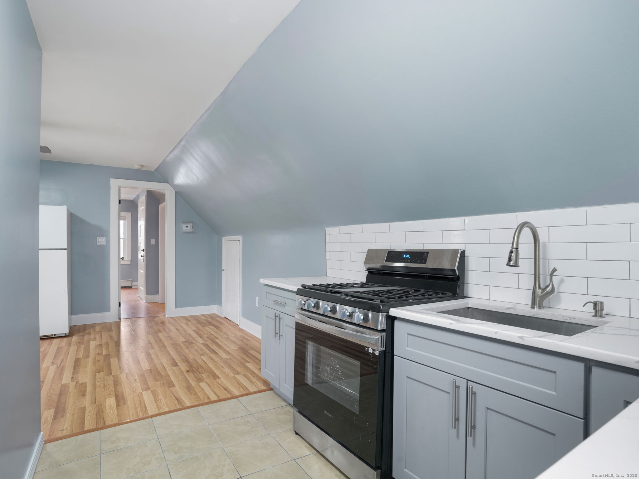 90 Amsterdam Avenue, Unit 2 Bridgeport, CT 06606 - Photo 4 of 10 a kitchen with granite countertop a sink stove and cabinets