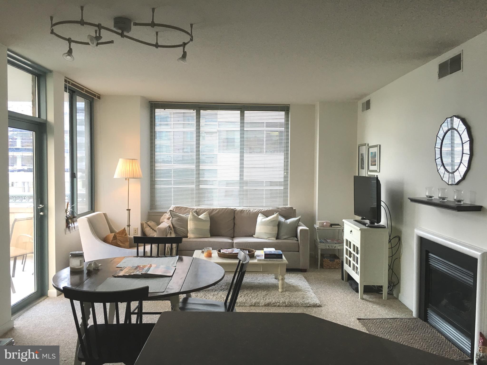 a living room with furniture a fireplace and a large window