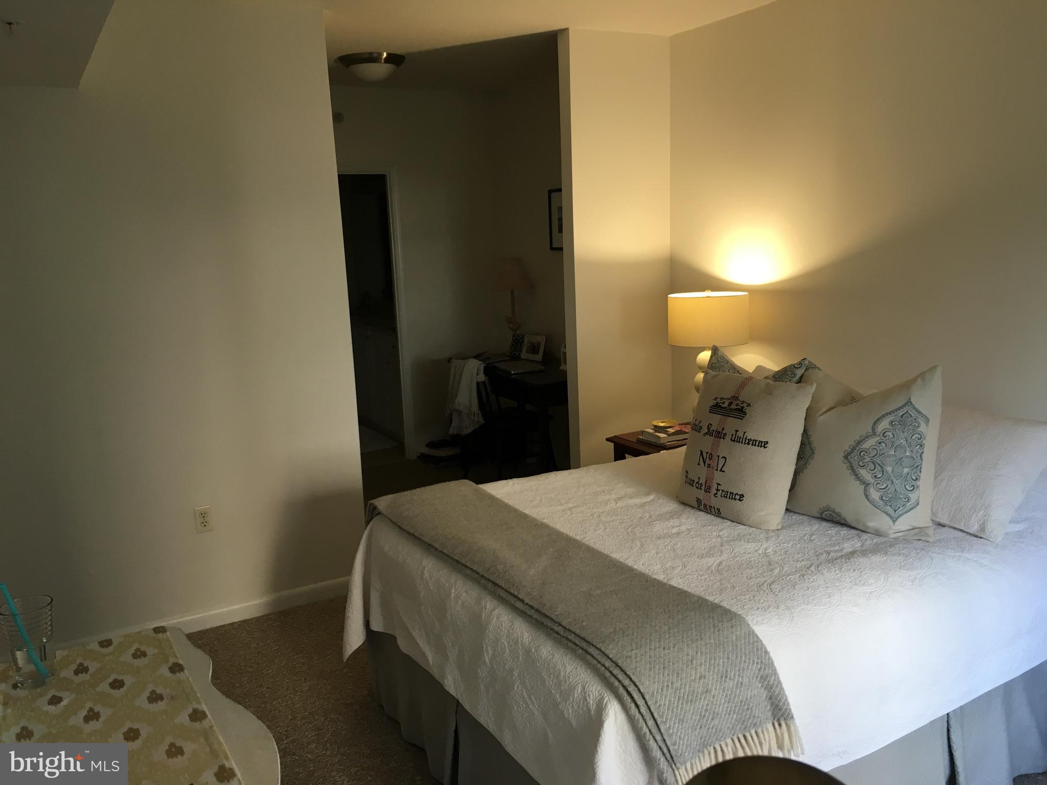 851 North Glebe Road, Unit 419 Arlington, VA 22203 - Photo 11 of 19 a bedroom with a bed and a lamp on the dresser