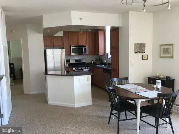 a kitchen with stainless steel appliances a dining table and chairs
