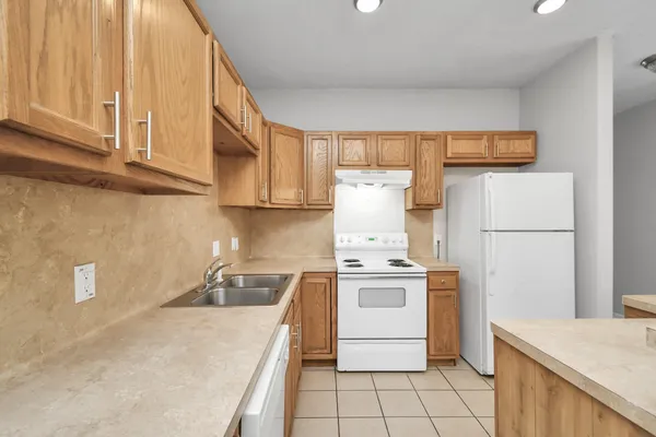 a kitchen with a stove a refrigerator and a sink