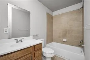 a bathroom with a bathtub shower sink vanity mirror and toilet