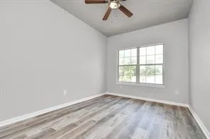 an empty room with a window and a ceiling fan