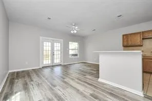 a view of an empty room with window and wooden floor