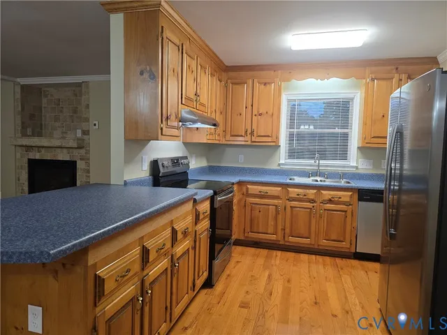 a kitchen with stainless steel appliances granite countertop a stove a sink and a refrigerator