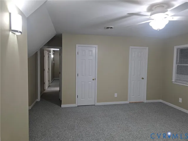 a view of empty room with window and ceiling fan