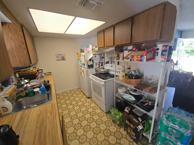a view of a kitchen with fridge and workspace