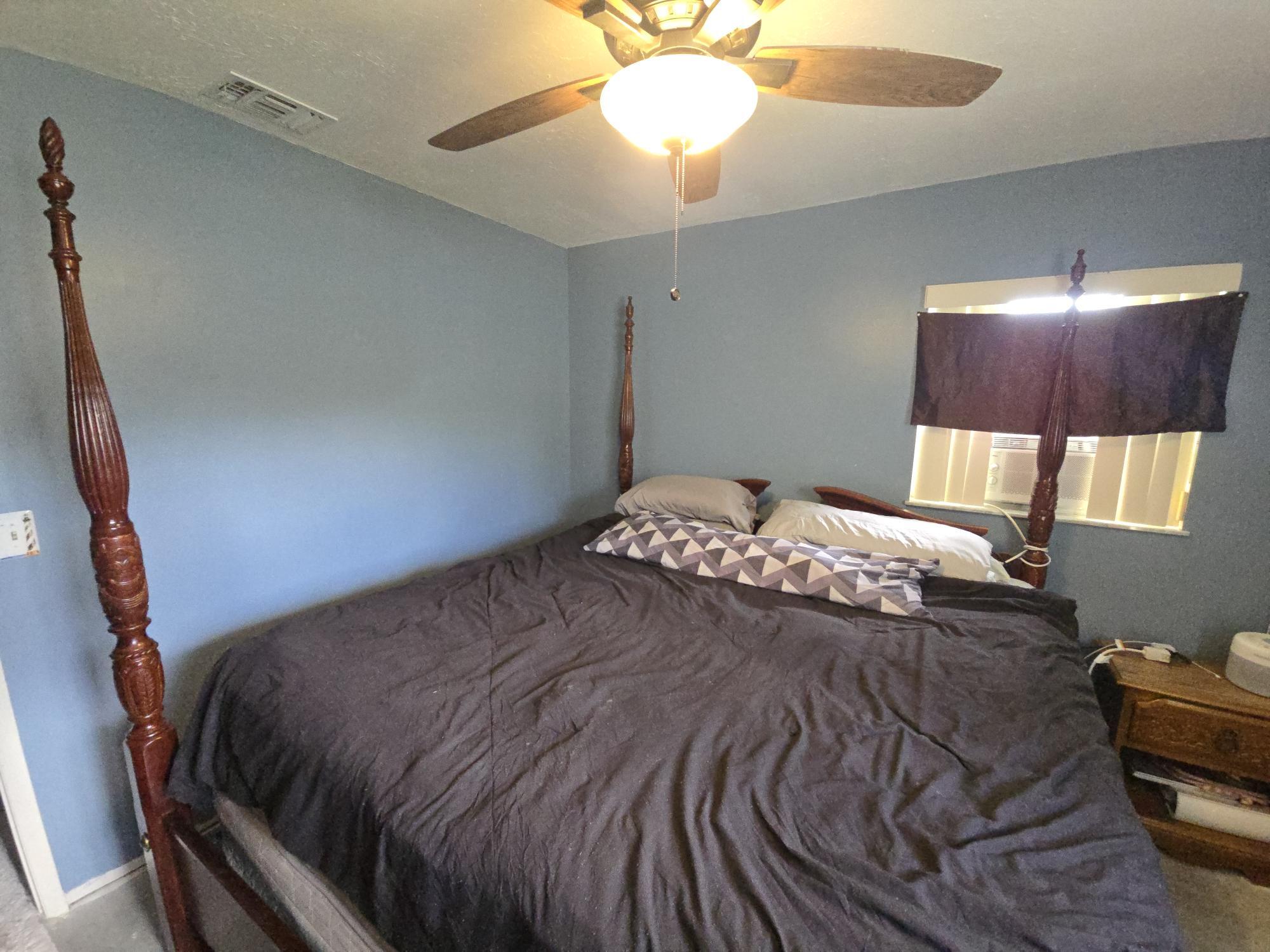 1346 23rd Avenue Southwest Vero Beach, FL 32962 - Photo 14 of 31 a bedroom with a bed and a lamp
